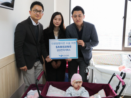 '사랑의 달팽이' 관계자(가운데)와 삼성전자서비스 관계자들이 인공와우 수술을 받은 아이와 함께 사진 촬영을 하고 있다.  삼성전자서비스 제공